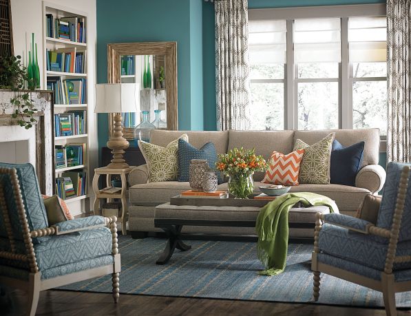 Although the sofa and leather cocktail ottoman in this room are neutral, the color and patterns on pillows and accent walls keep the room from being boring! 